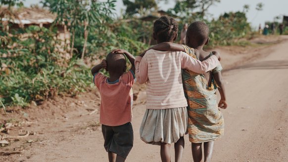 Children in Uganda walking together arm in arm - War Child project